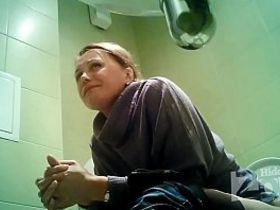 Взрослая женщина зашла в общественный туалет и не подозревая о скрытой камере стала справлять нужду