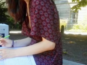 Молодая студентка попалась на камеру с оголенной сиськой пока делала работу на лавке